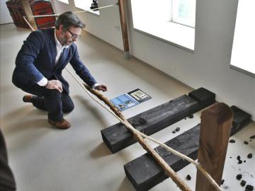 El director del Museo de la Mina de Arnao, Iván Muñiz, con el resto de las vías que se exponen en el museo