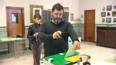 Los andaluces votan con el paraguas en la mano y con el móvil para hacerse un 'selfie'