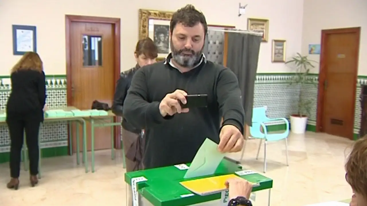 Los andaluces votan con el paraguas en la mano y con el móvil para hacerse un 'selfie'