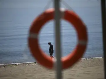 Un turista pasea por la orilla del mar en una playa Un turista pasea por la orilla del mar en una playa