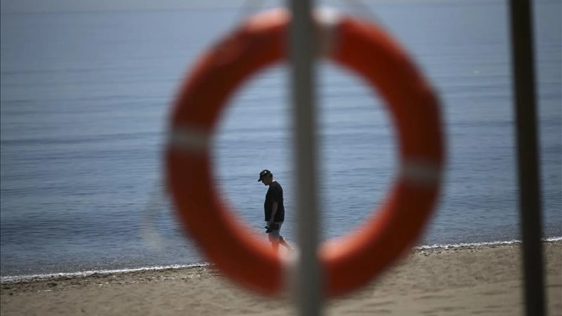 Un turista pasea por la orilla del mar en una playa Un turista pasea por la orilla del mar en una playa