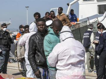 Un grupo de inmigrantes rescatado por un barco RBD desembarca al puerto de Corigliano Calabro (Italia) 