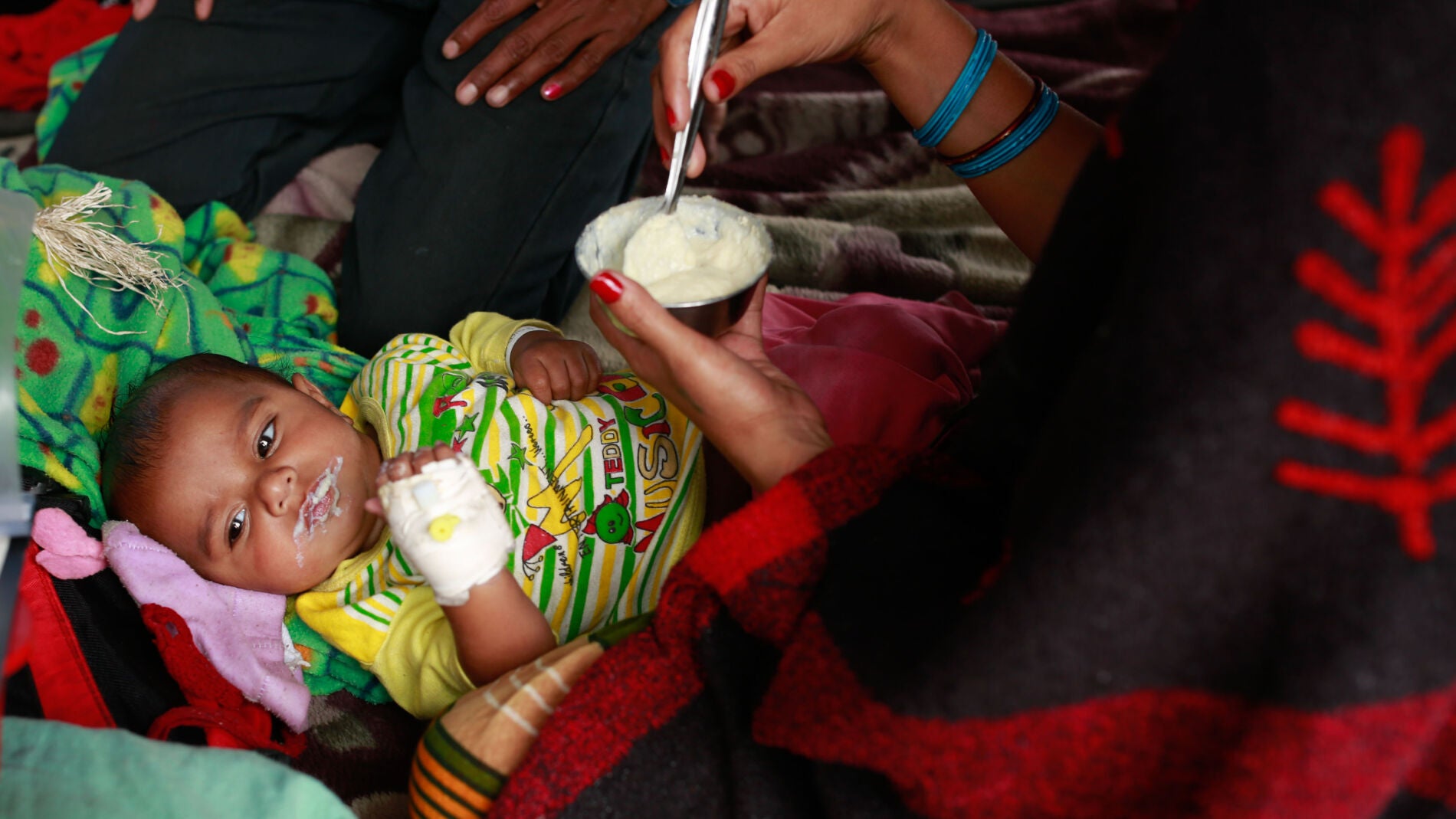 Un beb&eacute; es alimentado por su madre en un campamento de afectados en Nepal.
