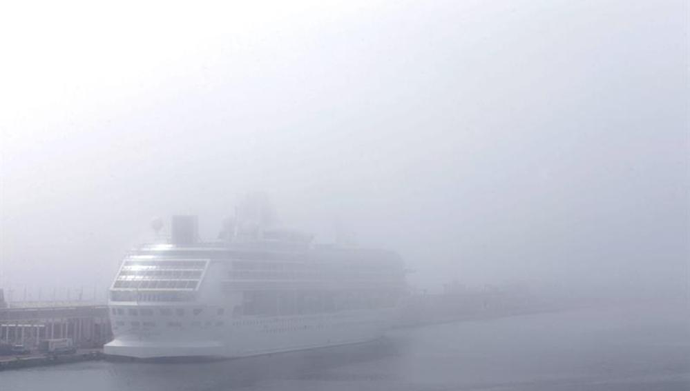 Un trasatlántico envuelto en niebla en el puerto de Barcelona.