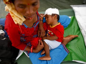 Una mujer nepalí sostiene a su hijo un día después del nuevo terremoto