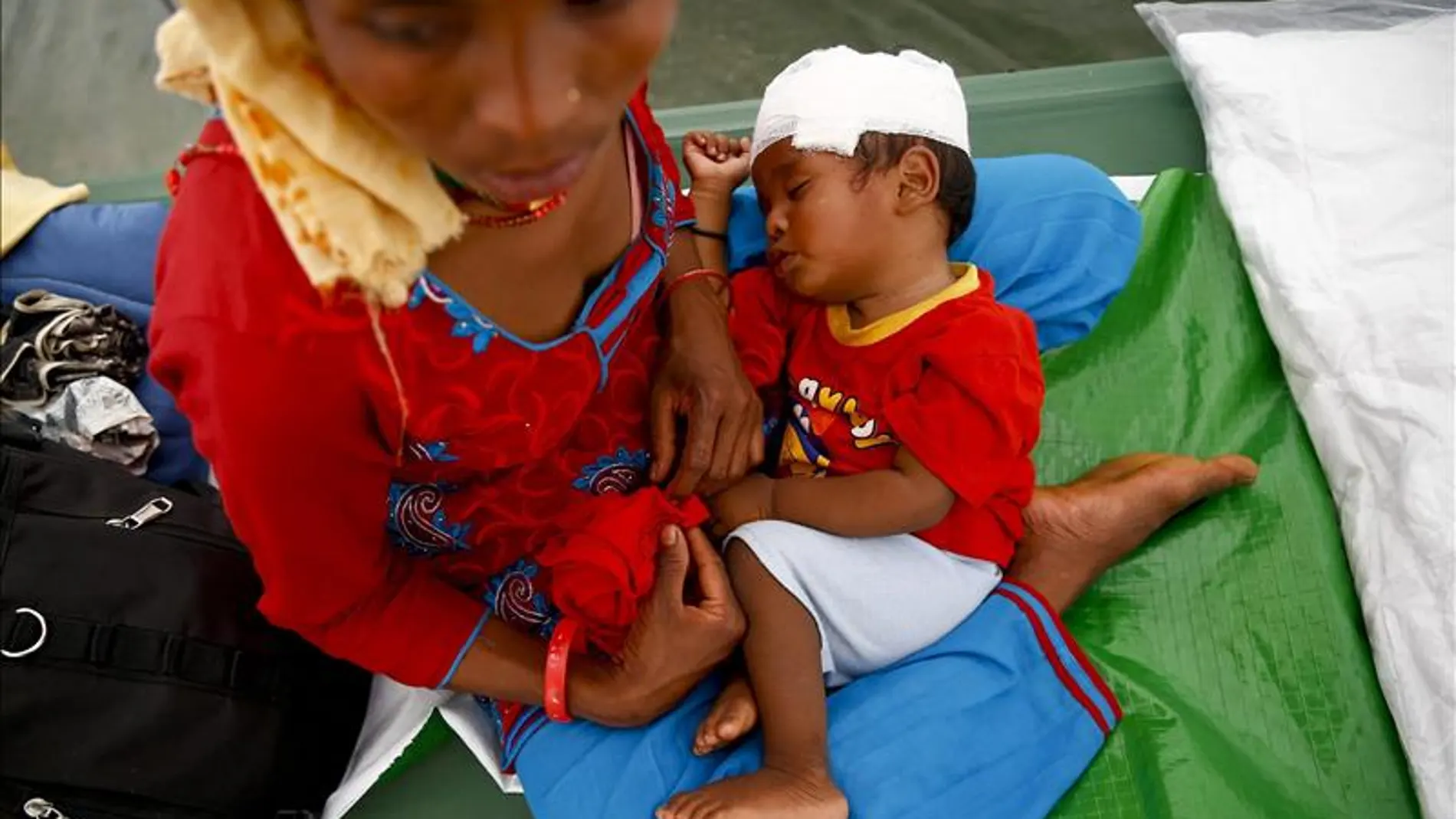 Una mujer nepalí sostiene a su hijo un día después del nuevo terremoto Una mujer nepalí sostiene a su hijo un día después del nuevo terremoto