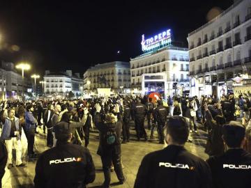 Miembros del movimiento 15M, vigilados por policías nacionales en la Puerta del Sol
