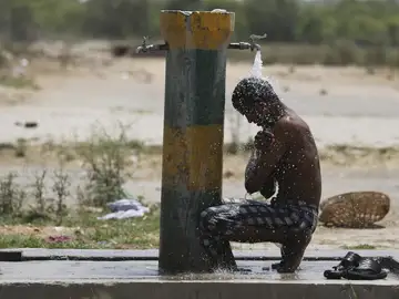 Un hombre se refresca ante la ola de calor en India Un hombre se refresca ante la ola de calor en India