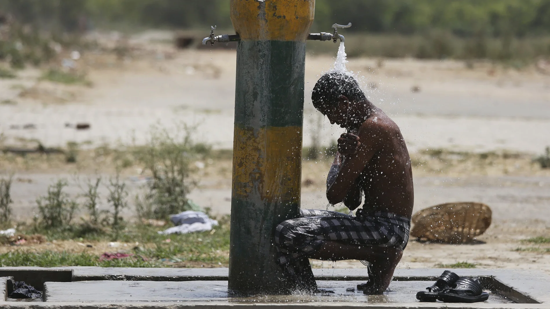 Un hombre se refresca ante la ola de calor en India Un hombre se refresca ante la ola de calor en India