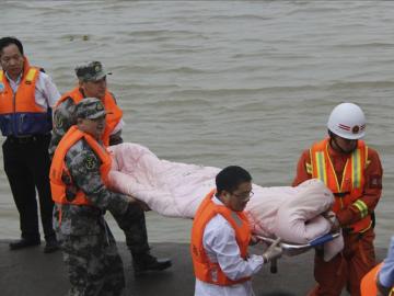 Miembros de los servicios de rescate trasladan a un superviviente del naufragio