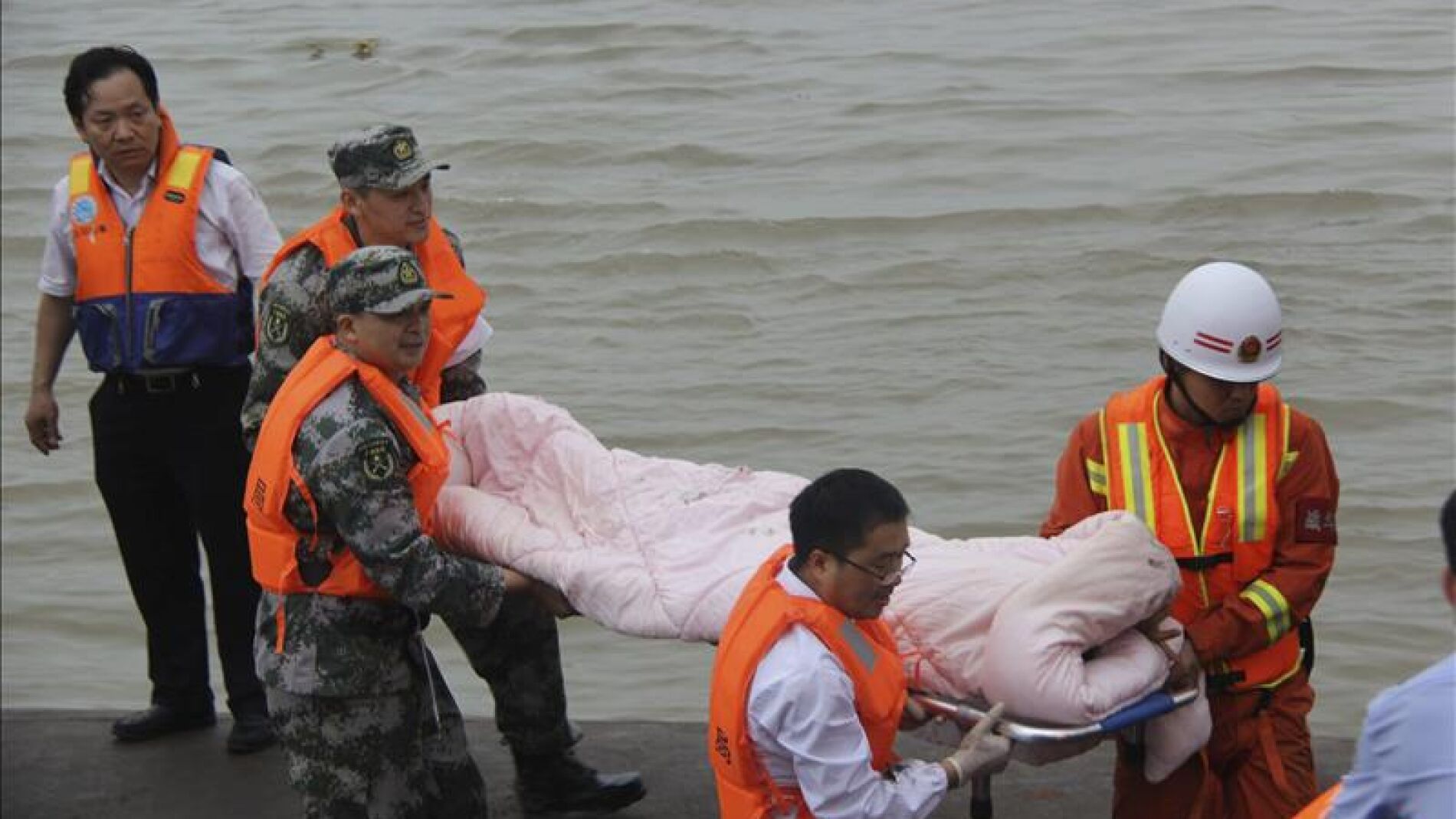 Miembros de los servicios de rescate trasladan a un superviviente del naufragio