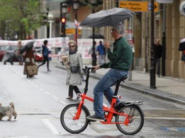 Un señor se resguarda de la lluvia