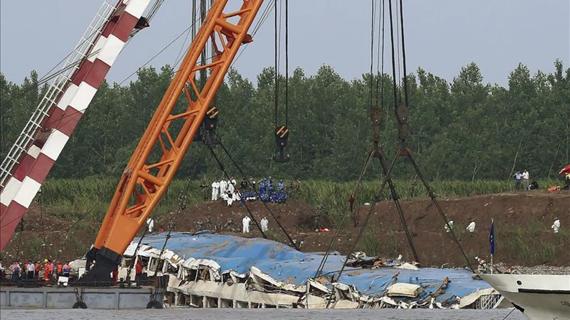 Una grúa saca del agua el barco naufragado en el río Yangtsé Una grúa saca del agua el barco naufragado en el río Yangtsé