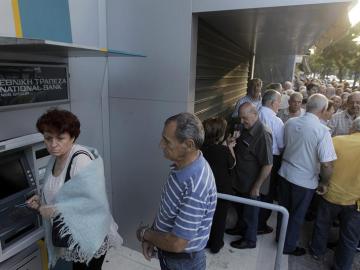 Jubilados sacan dinero de un cajero en Grecia.