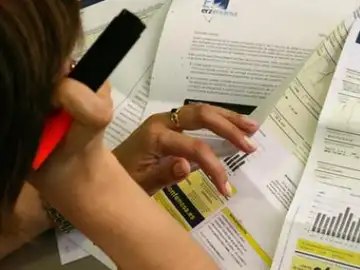 Una mujer estudia su factura de la luz Una mujer estudia su factura de la luz