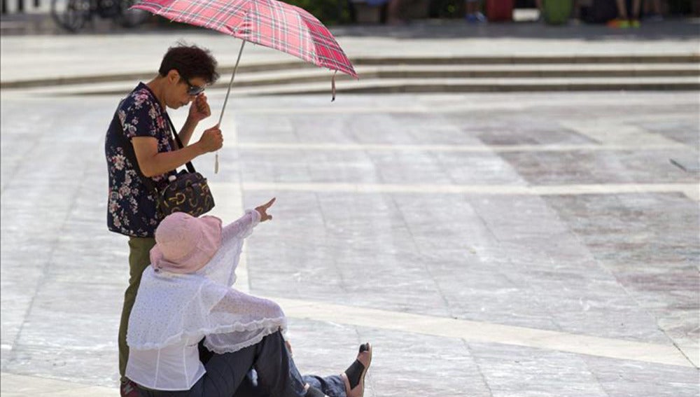 Dos turistas se protegen del calor.