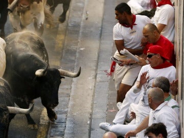 Un astifino toro del Conde de la Maza amenaza a lo mozos que se acumulan en el lateral del recorrido