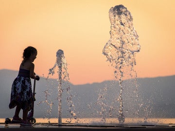 Una niña se refresca en una fuente para combatir el calor en Francia