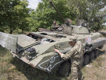 Voluntarios del ejército ucraniano examinando un tanque que perteneció a los prorrusos