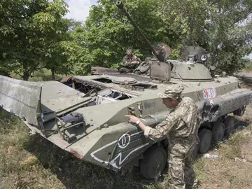 Voluntarios del ejército ucraniano examinando un tanque que perteneció a los prorrusos Voluntarios del ejército ucraniano examinando un tanque que perteneció a los prorrusos