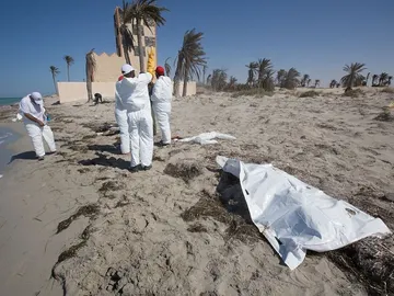 Voluntarios de la Media Luna Roja recogiendo los restos de un inmigrante en Libia Voluntarios de la Media Luna Roja recogiendo los restos de un inmigrante en Libia
