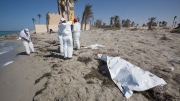 Voluntarios de la Media Luna Roja recogiendo los restos de un inmigrante en Libia
