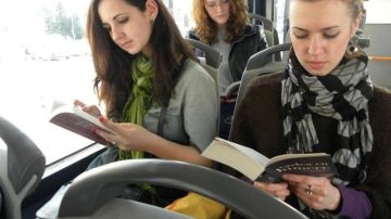 Tres mujeres leen libros en un autobús de Cluj Napoca