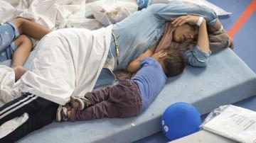 Varias personas descansan en un centro para refugiados de Deggendorf, Alemania
