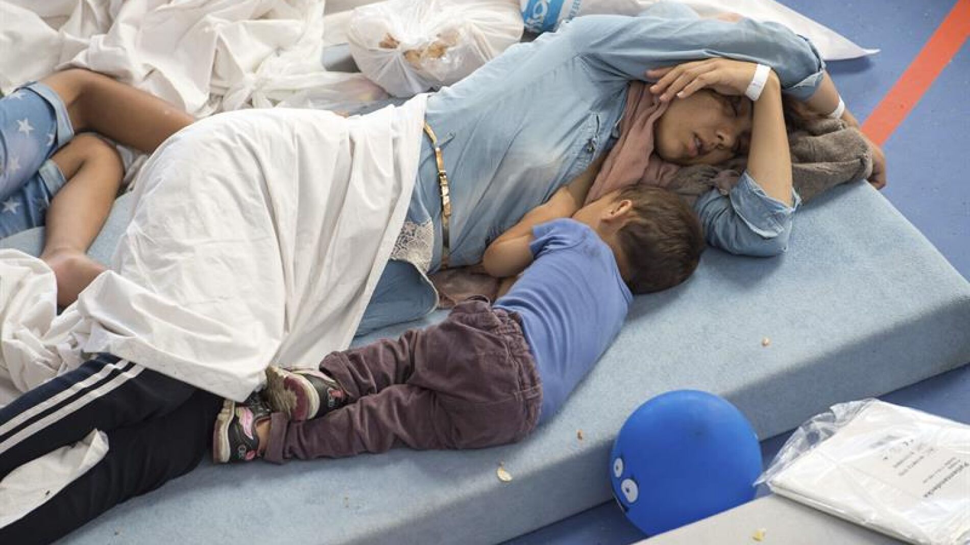 Varias personas descansan en un centro para refugiados de Deggendorf, Alemania
