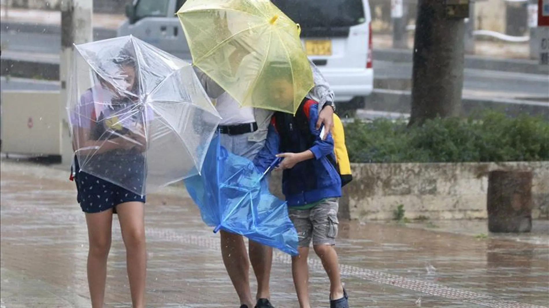 Varios viandantes luchan contra los fuertes vientos y la lluvia Varios viandantes luchan contra los fuertes vientos y la lluvia