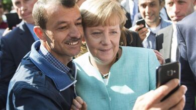 Merkel visita un centro de refugiados en Berlín y se hace selfies con ellos