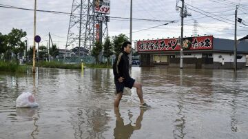 Un joven se abre paso entre las calles abnegadas por el agua en Japón.