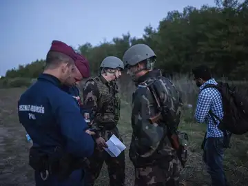 Policías y soldados comprueban la documentación de un refugiado en la frontera entre Serbia y Hungría. Policías y soldados comprueban la documentación de un refugiado en la frontera entre Serbia y Hungría.
