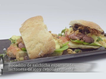 Bocadillo de salchicha esparracada, lactonesa de ajo y cebolla crujiente