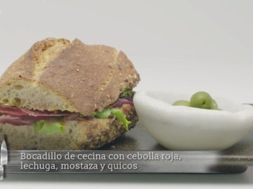 Bocadillo de cecina con cebolla roja, lechuga, mostaza y quicos