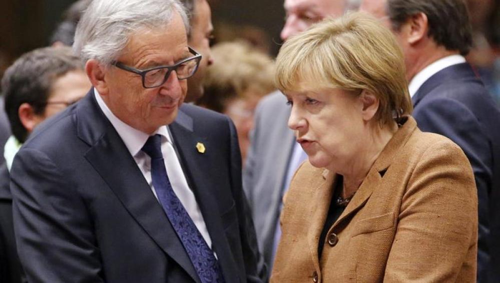 El presidente de la Comisión Europea, Jean Claude Juncker, conversa con la canciller alemena, Angela Merkel