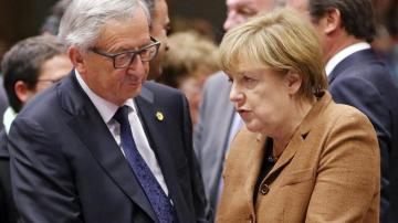 El presidente de la Comisión Europea, Jean Claude Juncker, conversa con la canciller alemena, Angela Merkel