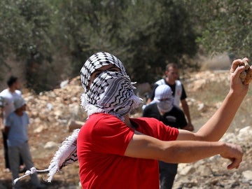 Un palestino se dispone a lanzar una piedra
