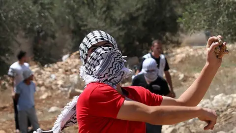 Un palestino se dispone a lanzar una piedra Un palestino se dispone a lanzar una piedra
