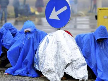 Refugiados esperan bajo la lluvia en la frontera entre Croacia y Eslovenia 