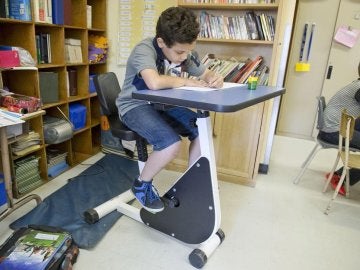 Imagen de un niño en el 'pupitre-bici'.