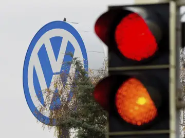 Logotipo de Volkswagen junto a un semáforo en rojo y naranja en Fallersleben, Alemania. Logotipo de Volkswagen junto a un semáforo en rojo y naranja en Fallersleben, Alemania.