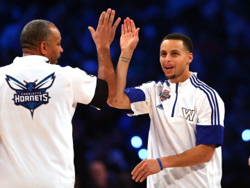 Stephen Curry (izq) choca la mano de su padre, Dell Curry (d)