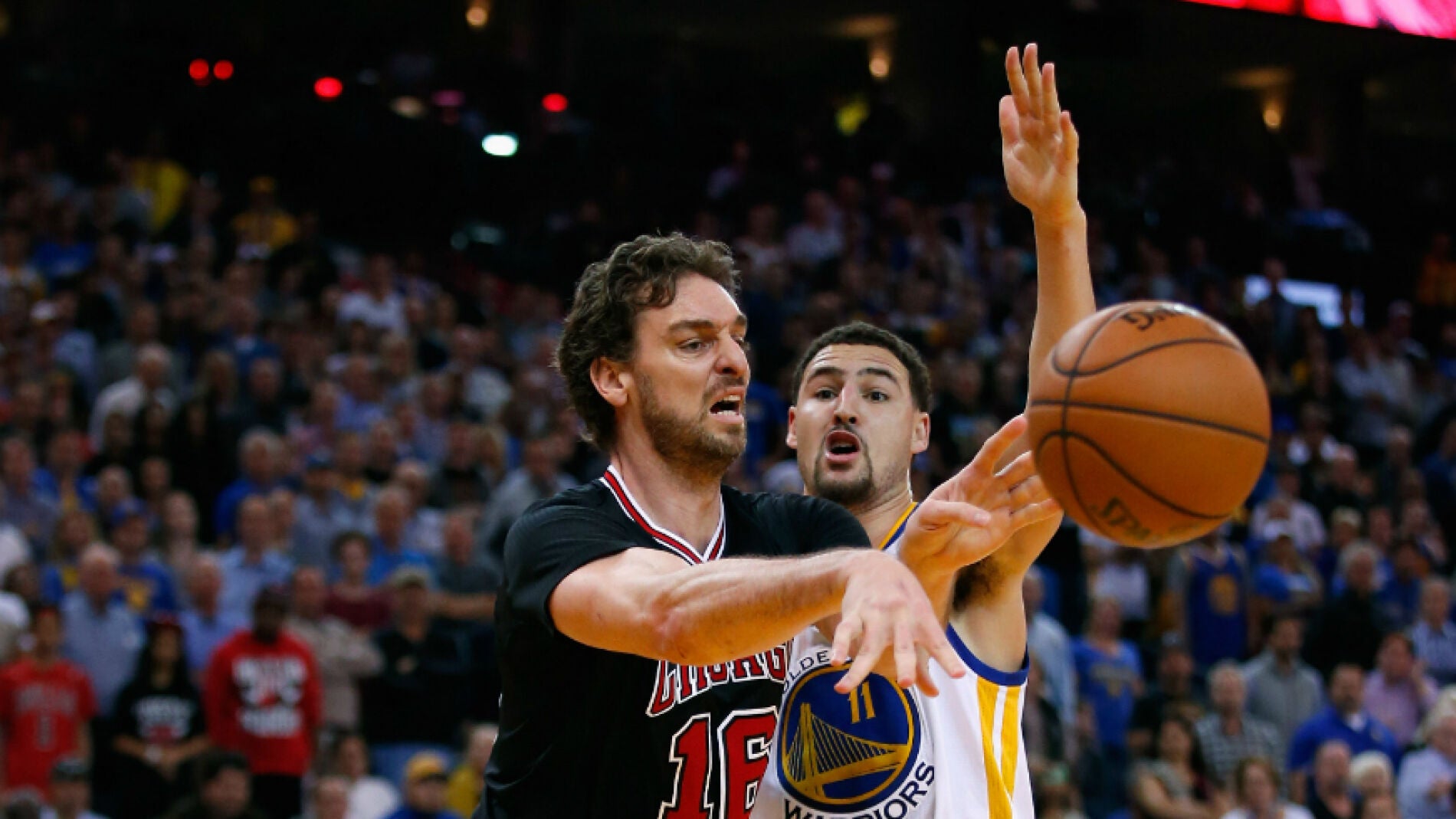 Pau Gasol pasa el bal&oacute;n ante la defensa de Klay Thompson