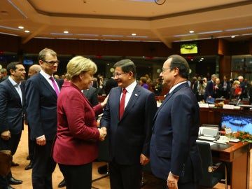 Ahmet Davutoglu, primer ministro turco, entre Angela Merkel y François Hollande