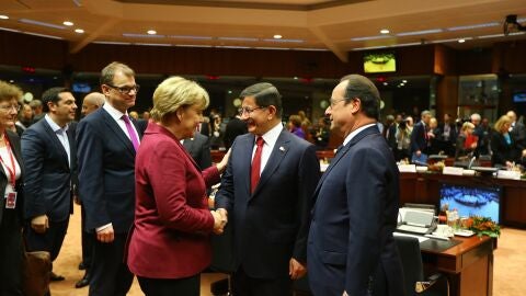 Ahmet Davutoglu, primer ministro turco, entre Angela Merkel y Fran&ccedil;ois Hollande