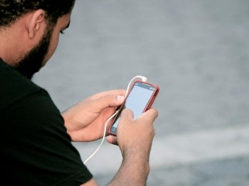 Un usuario mira su teléfono móvil