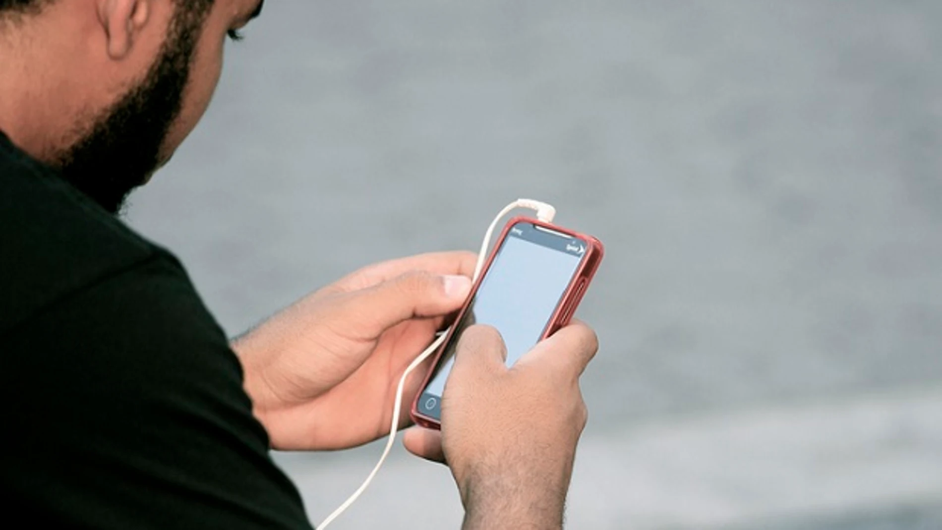 Un usuario mira su teléfono móvil Un usuario mira su teléfono móvil