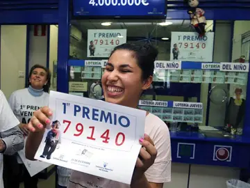 Una joven sonríe con una copia del número 79.140 Una joven sonríe con una copia del número 79.140