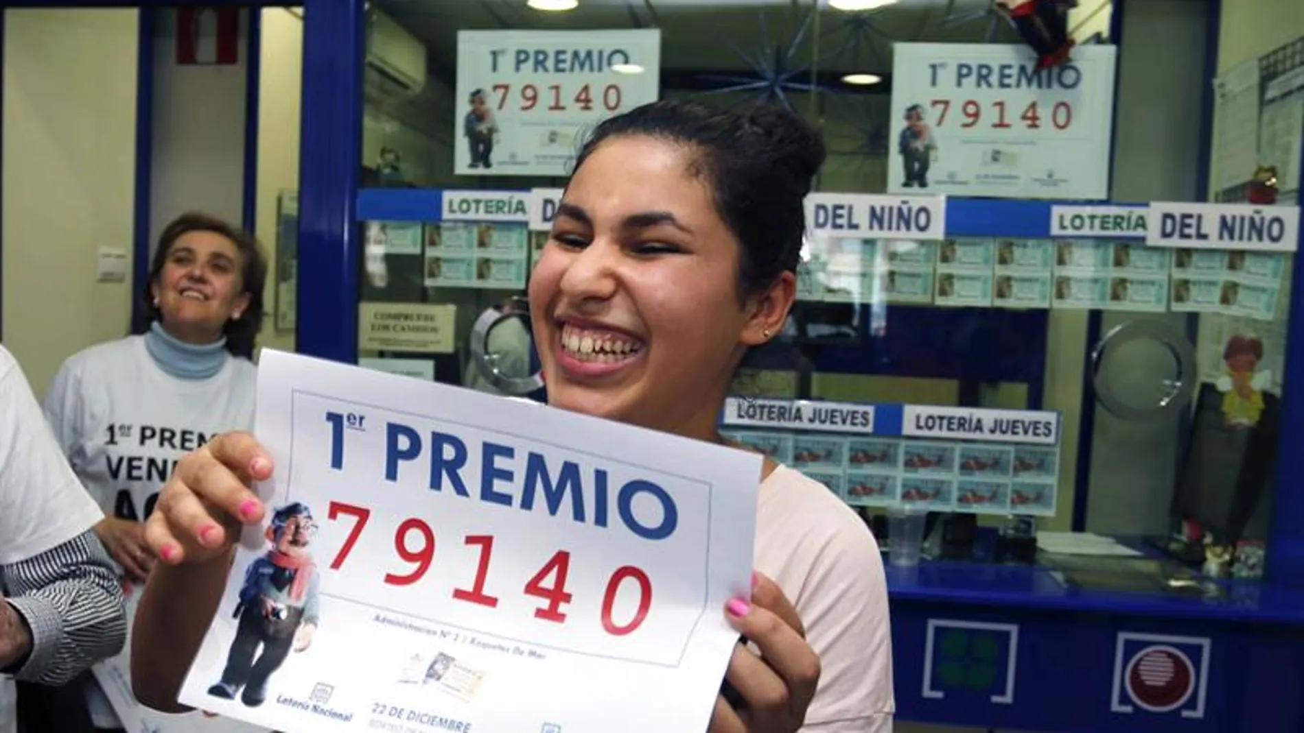 Una joven sonríe con una copia del número 79.140